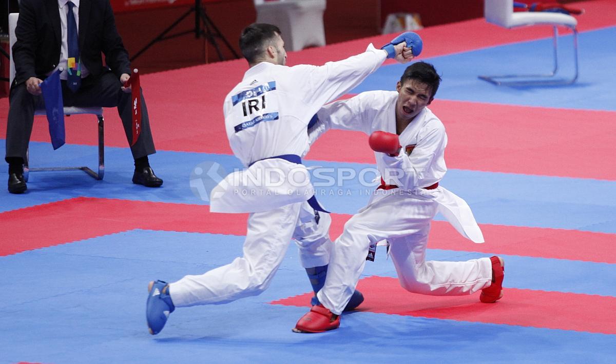 Atlet Karate Indonesia, Rifki Ardian Arrosyid (sabuk merah) melawan atlet Karate Iran, Amir Mahdi Zadeh (sabuk biru) pada babak final Karate kelas Putera -60kg di Plenary Hall JCC, Jakarta, Minggu (26/08/18). Riki menang 9-7 atas lawannya.