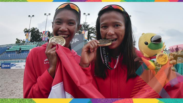 Pevoli pantai putri Indonesia Putu Dini Jasita Utami (kanan) dan Dhita Juliana (kiri) menggigit medali perunggu yang berhasil diraih setelah mengalahkan tiim voli Kazakhstan pada final voli pantai putri Asian Games 2018. Copyright: INASGOC