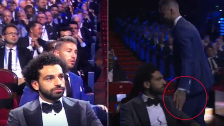 Sergio Ramos berikan sentuhan ke bagian bahu Mohamed Salah. Copyright: Sportbibble