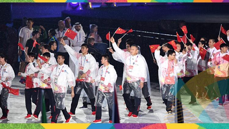 Kontingen China mengenakan jas hujan saat parade atlet di penutupan Asian Games 2018. Copyright: ARIEF BAGUS/Getty Images