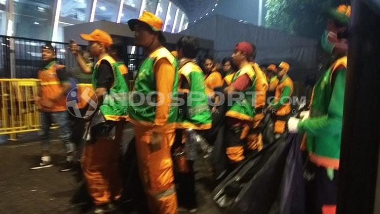 Petugas kebersihan langsung bersihkan sampah usai acara penutupan Asian Games 2018. Copyright: INDOSPORT/Zainal Hasan