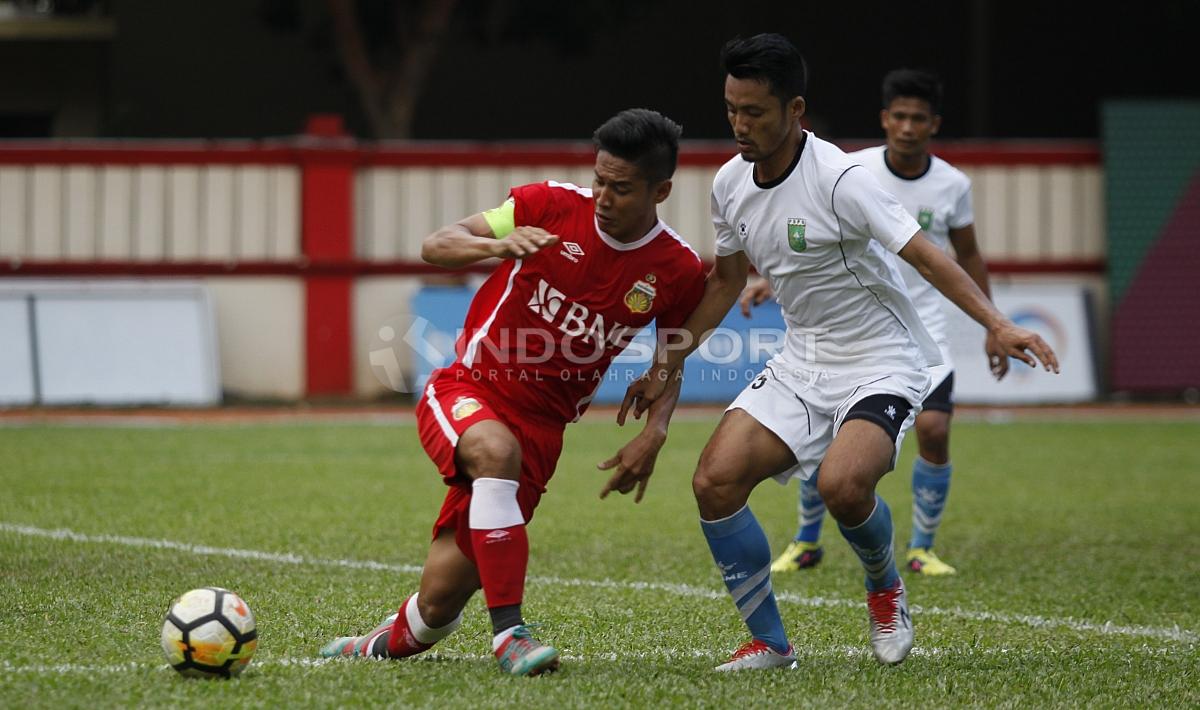 Kapten Bhayangkara FC, Indra Kahfi (kiri) mencoba melepaskan diri dari penjagaan pemain PSPS.