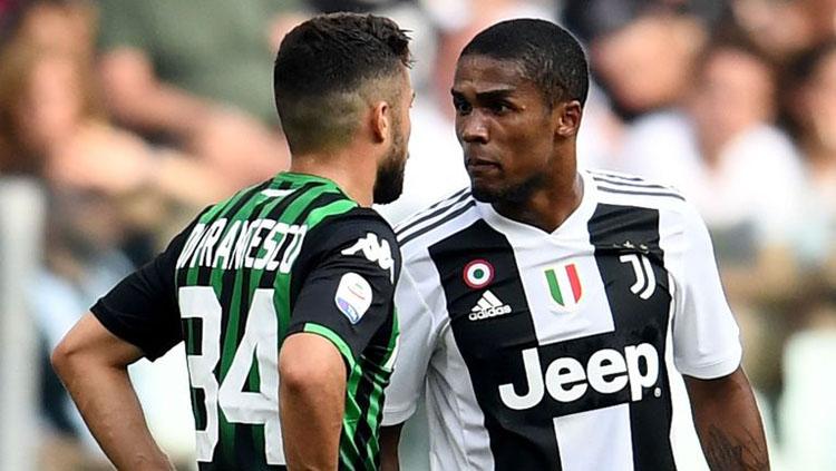 Douglas Costa saat insiden meludahi wajah Federico Di Francesco, Minggu (16/09/18) Copyright: Getty Images