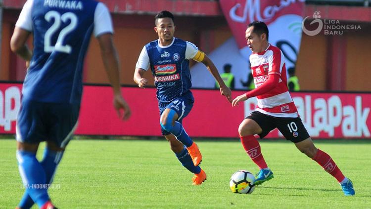 Slamet Nurcahyo berusaha melewati Dendi Santoso di laga Arema FC vs Madura United Liga 1 2018. Copyright: liga-indonesia.id