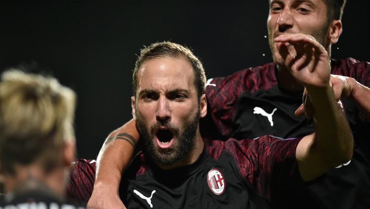 Gonzalo Higuain berselebrasi bersama pemain AC Milan lain usai menetak gol.