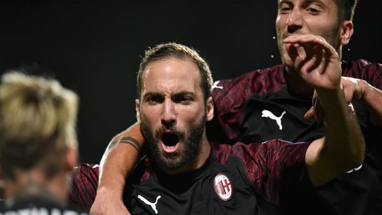 Gonzalo Higuain berselebrasi bersama pemain AC Milan lain usai menetak gol. - INDOSPORT