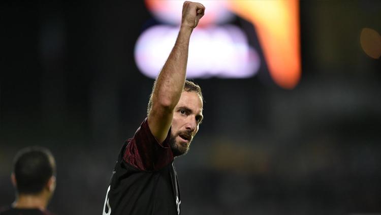 Gonzalo Higuain berselebrasi bersama pemain AC Milan lain usai menetak gol.