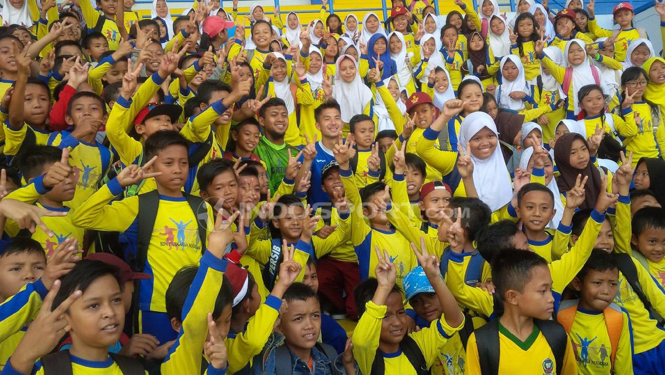 Dua pemain Persib, Kim Jeffrey dan Muhammad Natshir berfoto bersama ratusan anak SD di Stadion Sport Jabar Arcamanik, Kota Bandung, Kamis (27/09/2018). Copyright: Arif Rahman/Indosport.com