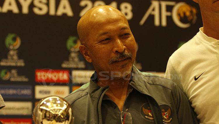 Pelatih Fakhri Husaini dan trofi Piala Asia U-16.