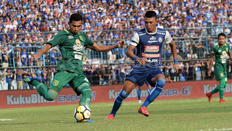 Dedik Setiawan berusaha mencuri bola dari penguasaan bek Persebaya. Copyright: Ian Setiawan/INDOSPORT