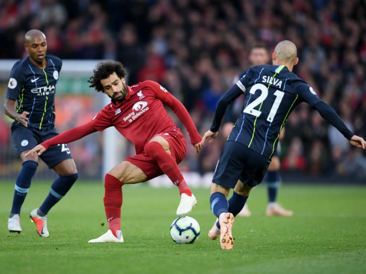 Mohamed Salah tengah berebut bola dengan David Silva. Copyright: Getty Images