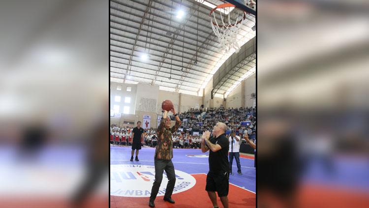 Gubernur Jawa Tengah, Ganjar Pranowo, sedang mencoba shooting yang dipandu oleh Associate Vice President Basketball Operations NBA, Carlos Barroca dan pada ajang Jr. NBA Coaches Academy pada hari Rabu (17/10) di GOR Sumber Waras, Semarang. - INDOSPORT