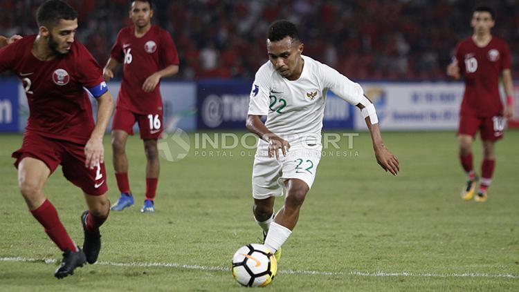Todd Rivaldo Ferre menguasai bola dan dibayang-bayangi pemain Qatar U-19.
