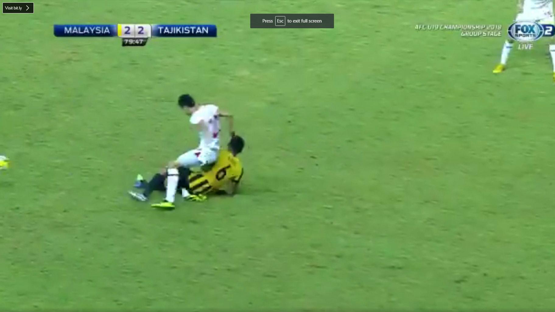 Pemain Malaysia Nabil Hakim saat melakukan tekel ke Khuseyn Nurmatov.