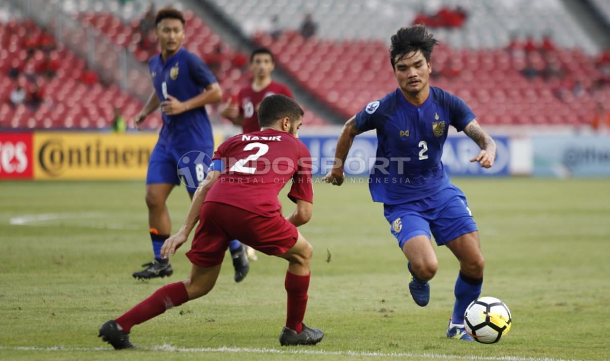 Pemain Thailand U-19 berhasil melewati pemain Qatar.