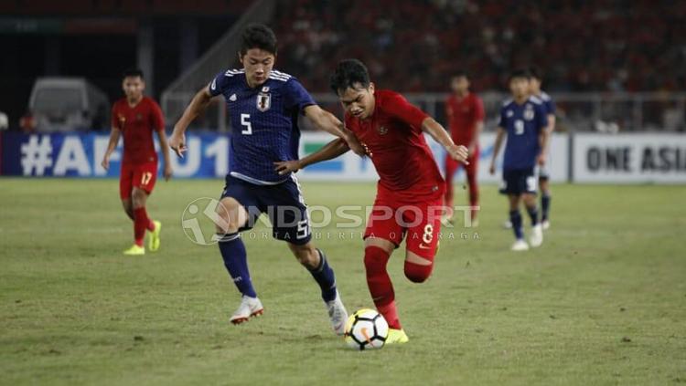 Witan Sulaeman berusaha menganmakan bola dari pemain Jepang Copyright: Herry Ibrahim/INDOSPORT