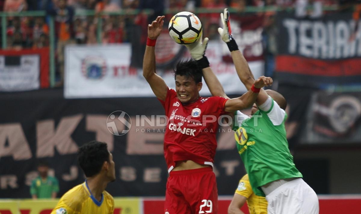 Sandi Sute tengah melakukan duel udara dengan pemain Barito Putera.