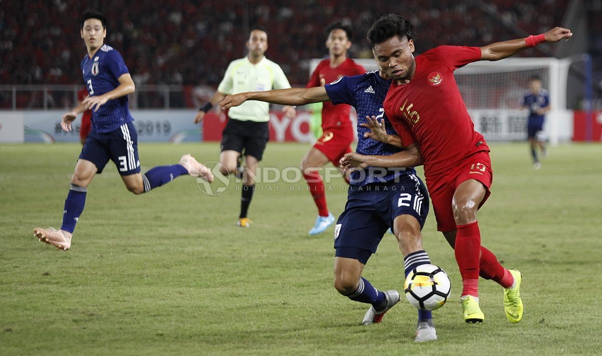Saddil Ramdani berebut bola dengan pemain Jepang.