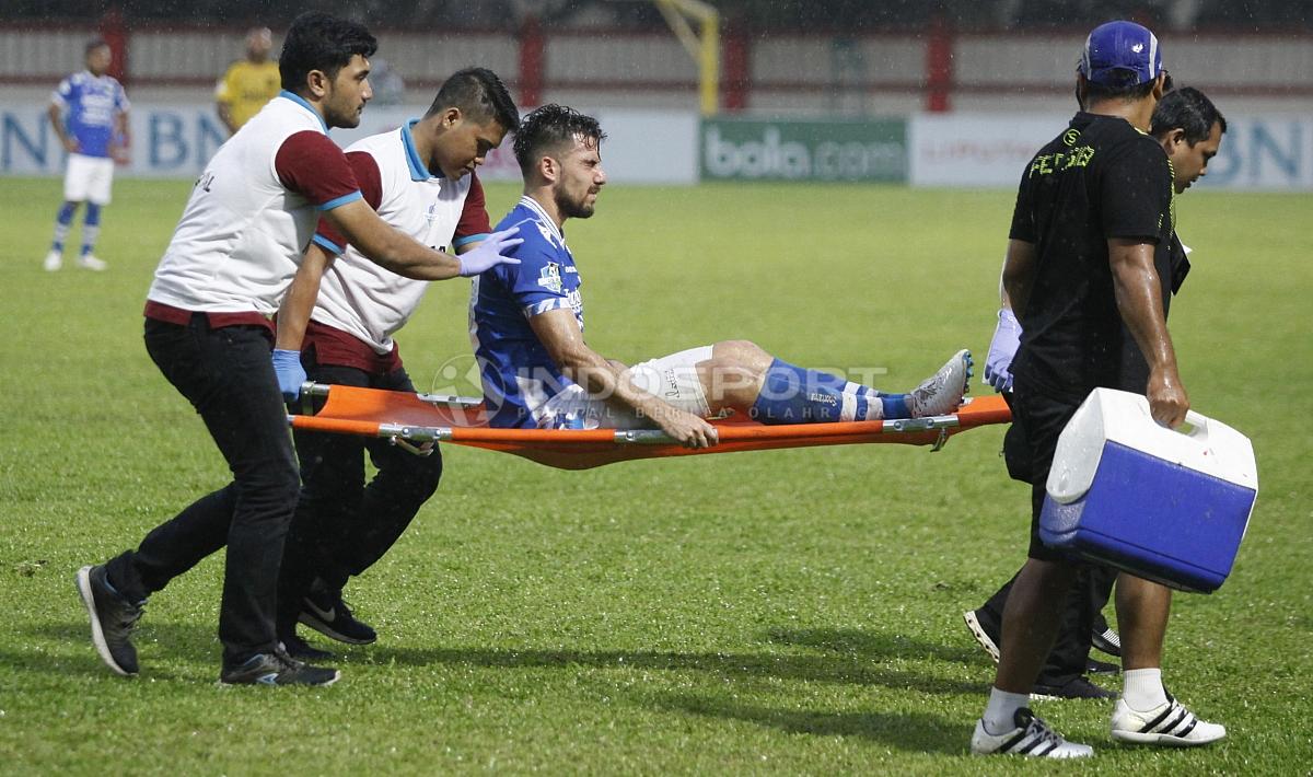 Striker Persib, Jonathan Bauman ditandu keluar karena cedera.