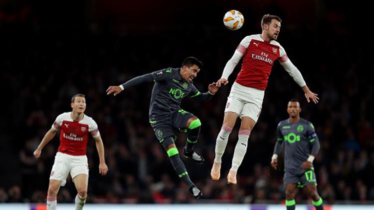 Duel udara antara Aaron Ramsey (kanan) dengan Marcos Acuna (kiri). Copyright: Richard Heathcote/Getty Images