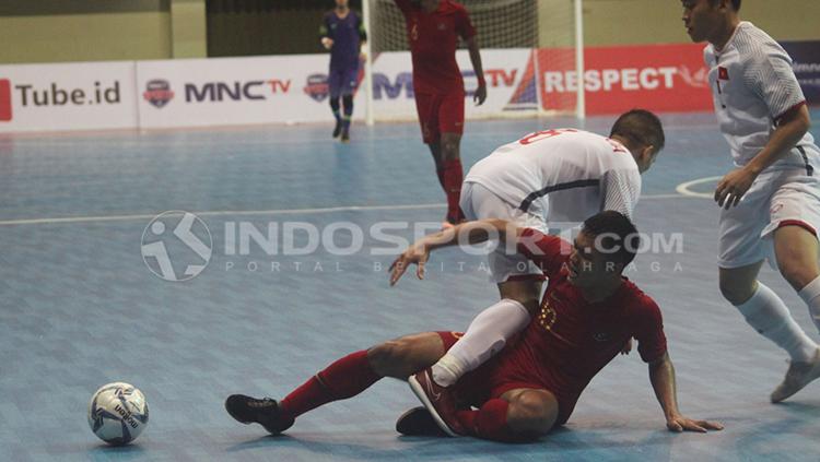 Pemain Timnas Indonesia, Anri Kustiawan, terjatuh usai dijegal dua pemain Vietnam.
