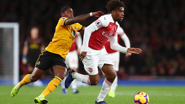 Alex Iwobi mencoba melewati adangan pemain Wolverhamtpon. Copyright: Clive Rose/Getty Images