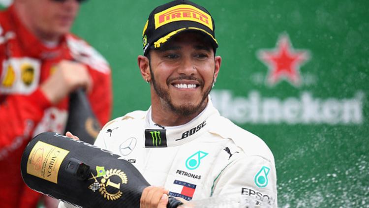 Lewis Hamilton berselebrasi usai memenangkan F1 GP Brasil.