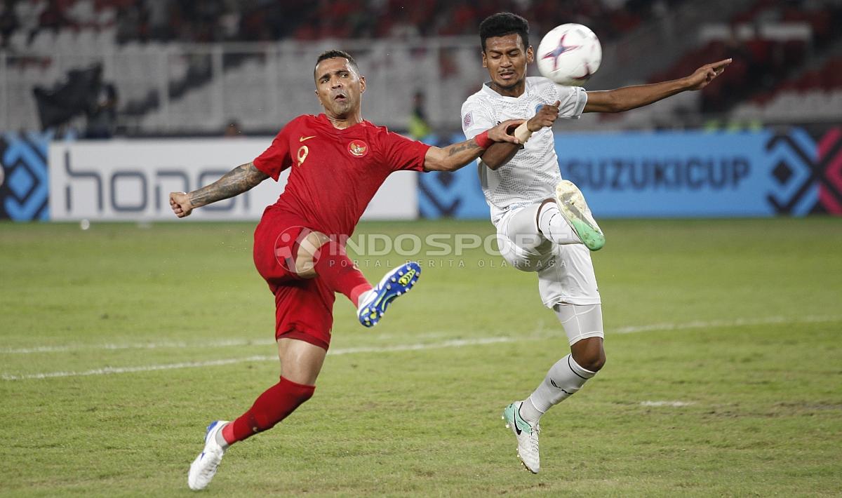 Aksi Alberto Goncalves menendang bola ke arah gawang Timor Leste diganggu pemain belakang Timor Leste.