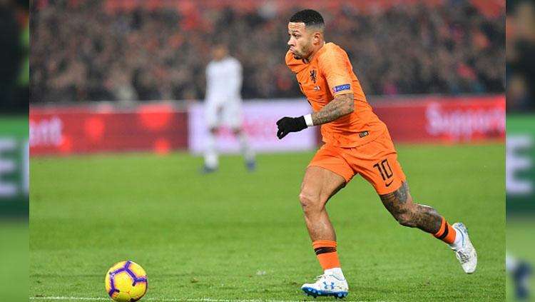 Memphis Depay berlari membawa bola. Copyright: Getty Images