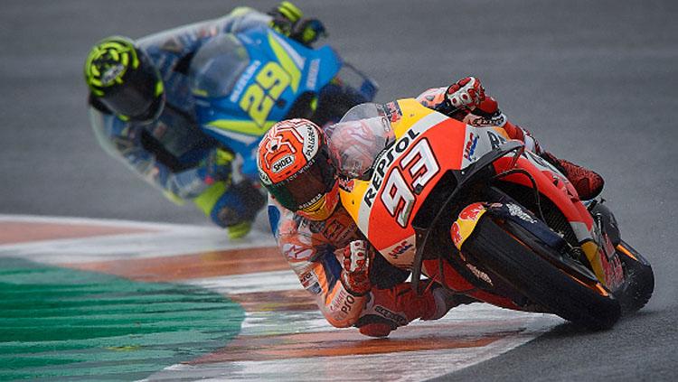 Pembalap MotoGP, Marc Marquez (depan) dan Andrea Iannone menggunakan jas hujan khusus pada latihan bebas pertama di MotoGP 2018 Valencia.