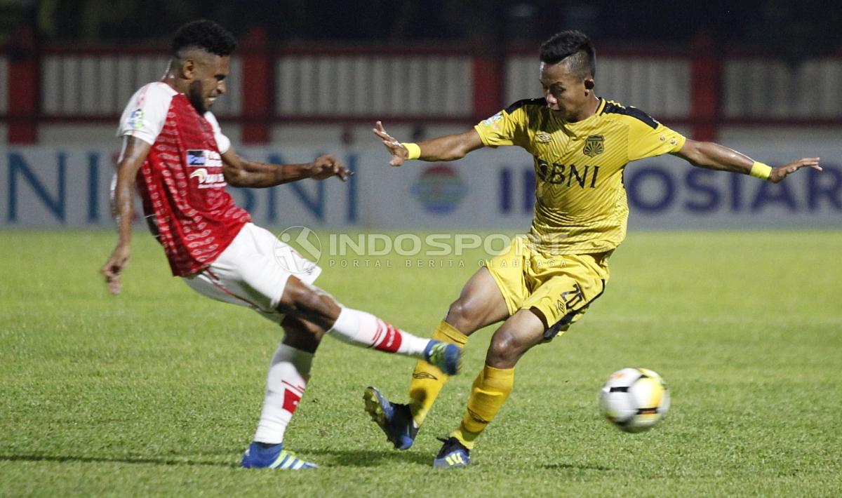 Pemain BFC, Sani Rizki bola dengan pemain Persipura, Imanuel Wanggai (kiri).