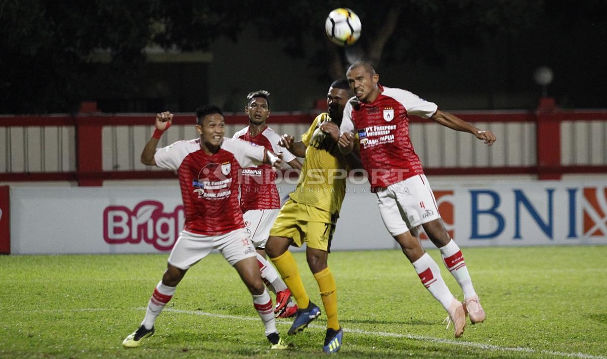 Ricardo Salampessy menghalau bola yang mengarah ke Vendry Mofu.