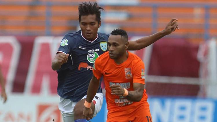 Titus Bonai duel dengan pemain Persela Lamongan