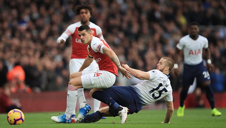 Granit Xhaka kehilangan bola setelah duel dengan Eric Dier di pertandingan Arsenal vs Tottenham Hotspur Copyright: Getty Images