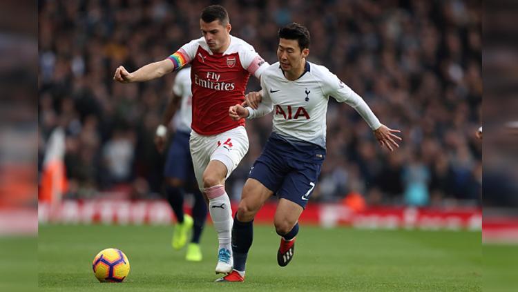 Son berusaha merebut bola dari Granit Xhaka di pertandingan Arsenal vs Tottenham Hotspur Copyright: Getty Images
