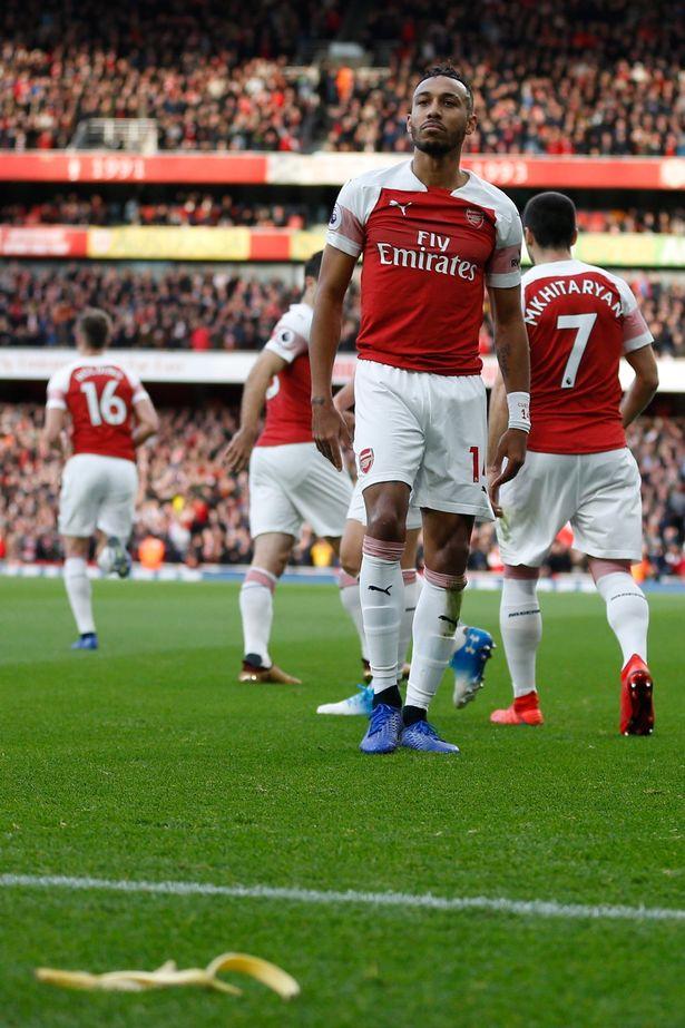 Striker Arsenal, Pierre-Emerick Aubameyang melakukan selebrasi dan dilempati kulit pisang oleh fans Tottenham. Copyright: INDOSPORT