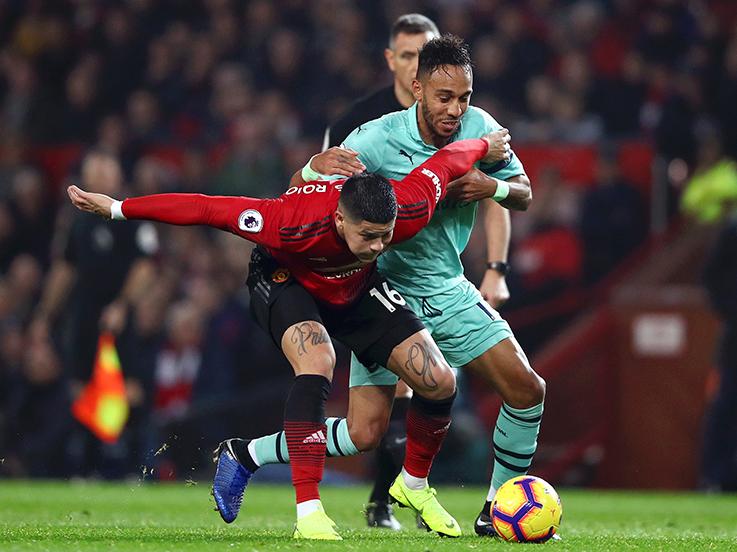 Marcos Rojo mendapat perlawanan dari Pierre-Emerick Aubameyang. Copyright: Indosport