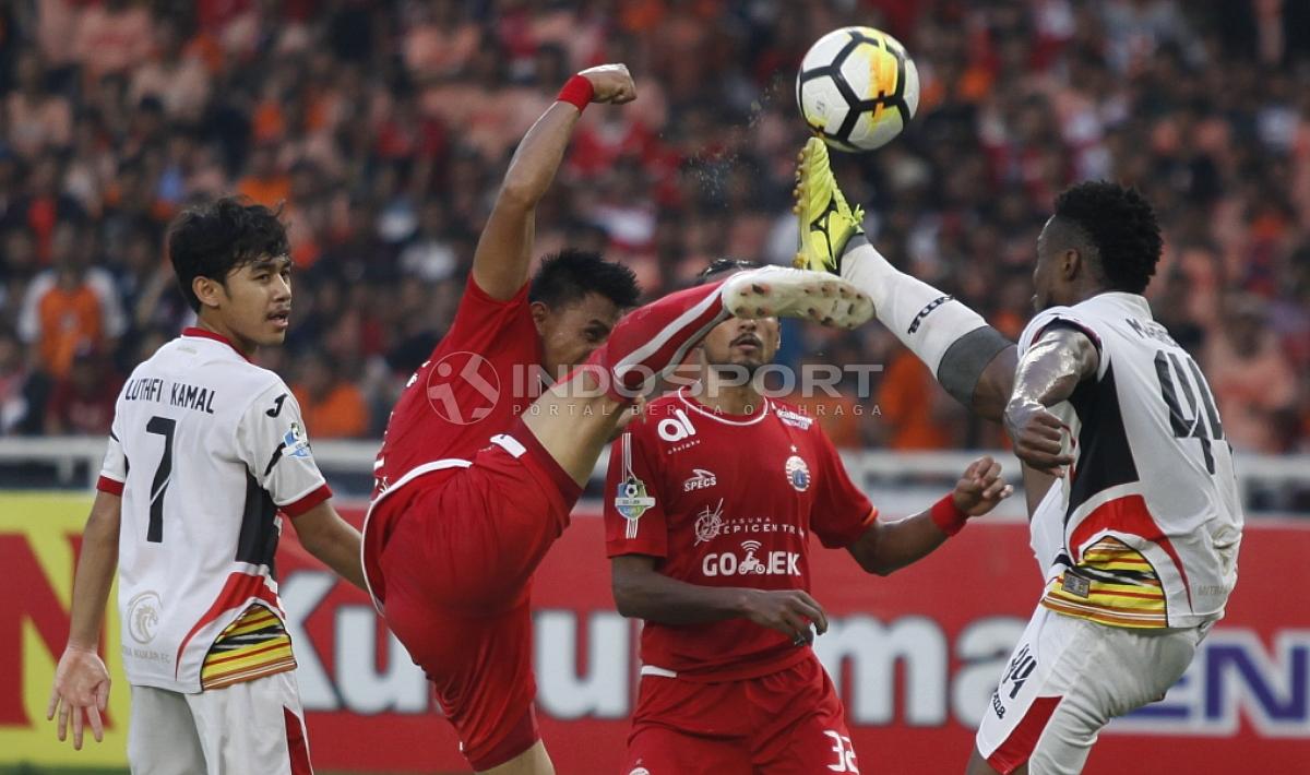 Pemain Persija Jakarta dan Mitra Kukar berusaha merebut bola yang melambung di udara.