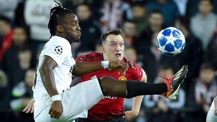 Wajah lucu Phil Jones saat menjaga Michy Batshuayi tertangkap kamera wartawan. Copyright: AFP/Getty Images