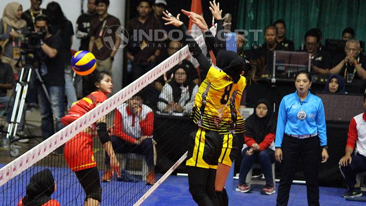 Pemain Jakarta PGN Popsivo memblok smash keras pemain Bandung BJB Pakuan Kokram Pimpichaya.