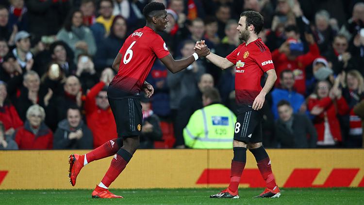 Paul Pogba berselebrasi bersama Juan Mata usai mencetak gol ke gawang Huddersfield. Copyright: Clive Brunskill/Getty Images