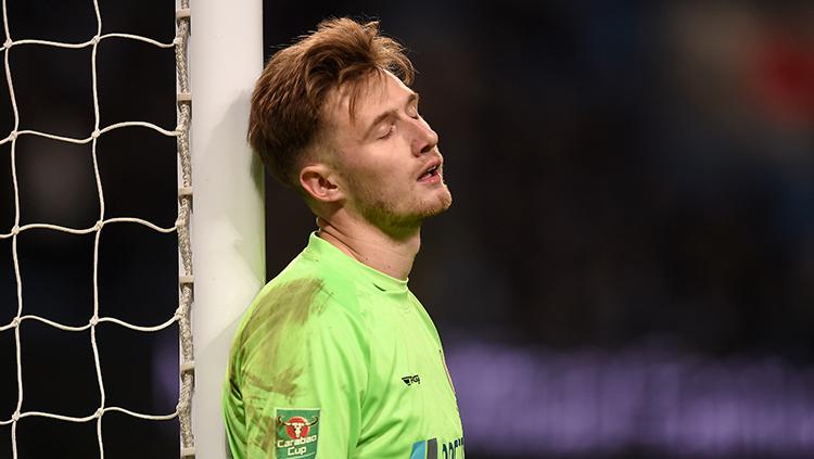 Bradley Collins kiper Burton tertunduk lesu setelah kalah banyak oleh Manchester City