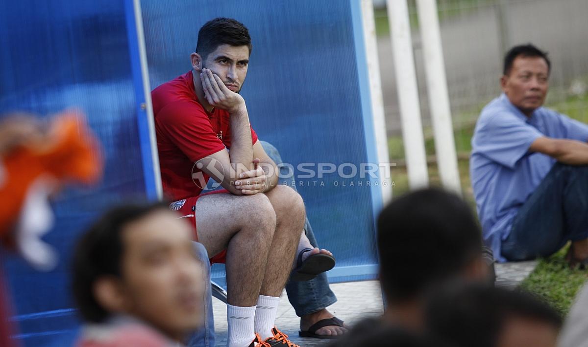 Pemain anyar Persija, Jakhongir Abdumuminov menyaksikan rekan-rekannya berlatih dari pinggir lapangan.