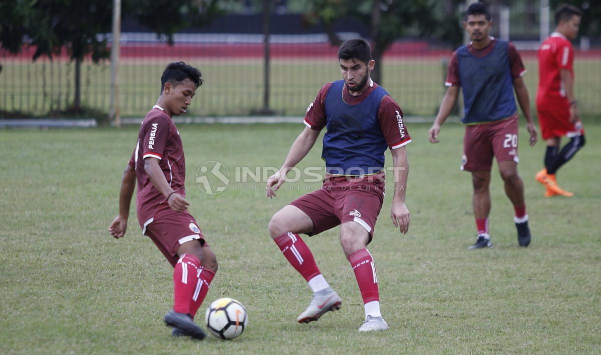 Pemain baru Persija asal Uzbekistan, Jakhongir Abdumuminov mencoba merebut bola dari rekannya dalam latihan.