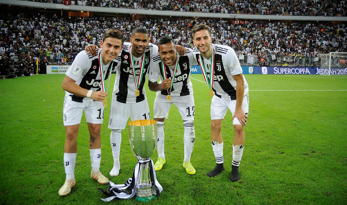 Paulo Dybala, Douglas Costa, Alex Sandro dan Rodrigo Bentancur melakukan foto bersama trofi yang baru mereka peroleh.