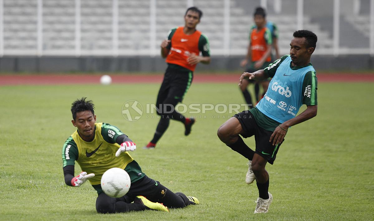 Kiper Satria Tama (kiri) menggagalkan peluang yang didapat Todd Rivaldo Ferre. Copyright: Herry Ibrahim/Football265.com