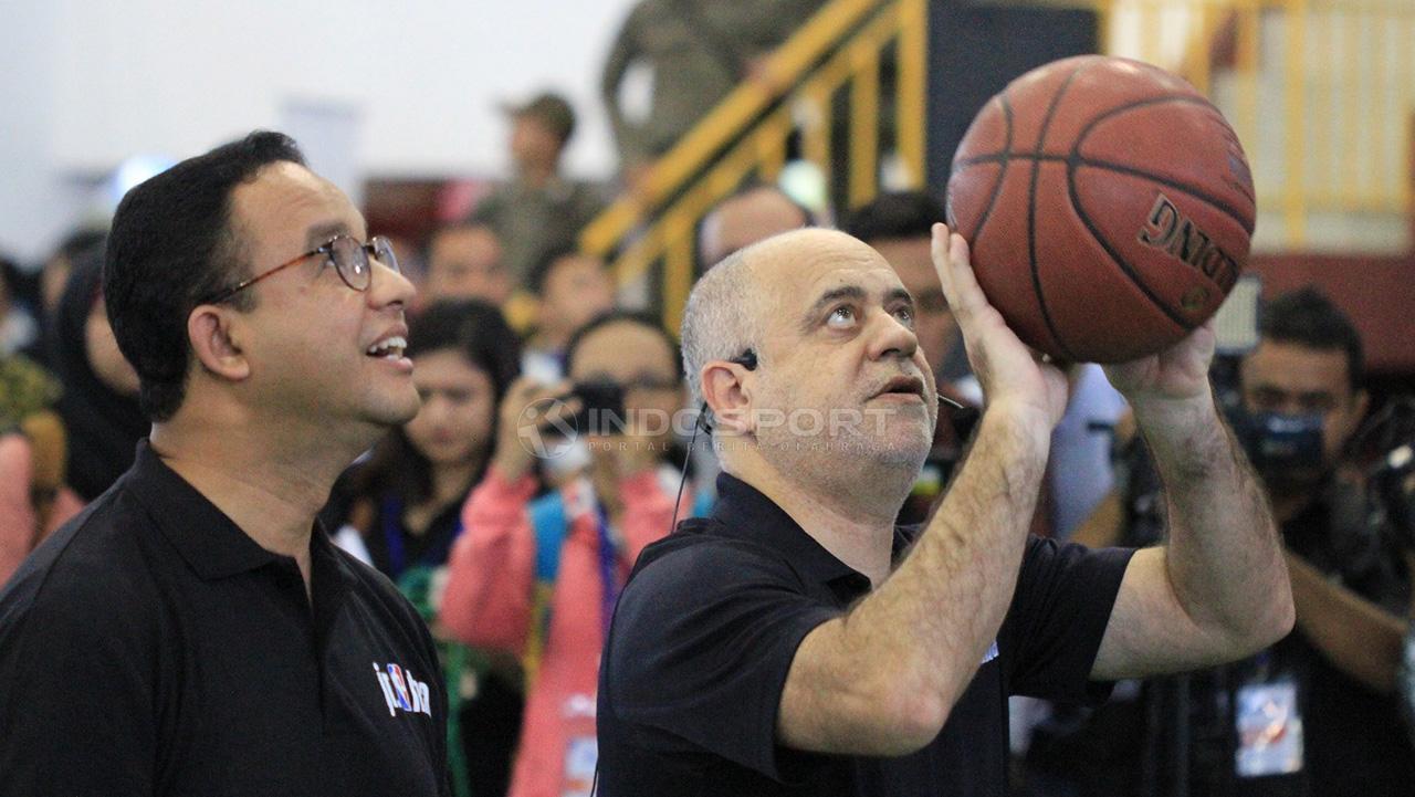 Head Coach Jr. NBA, Carlos Barroca (kanan) mencontohkan cara melempar bola basket yang benar kepada Gubernur DKI Jakarta, Anies Baswedan.