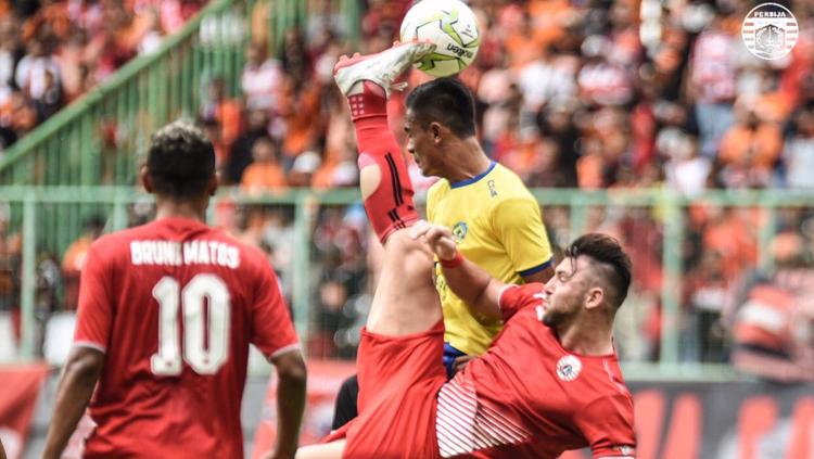 Marco Simic melakukan tendangan salto di atas kepala pemain Kepri FC