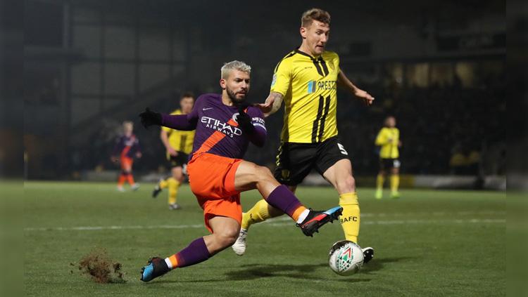 Striker Manchester City Sergio Aguero menendang bola ke arah gawang Burton Albion di Carabao Cup, Kamis (24/01/19).