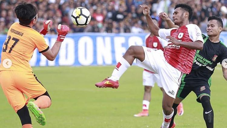 Pemain Persipura Jayapura mengontrol bola dari pemain Persidago